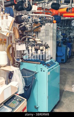 Macchina per maglieria industriale ad alta tecnologia con filettature guida. Produzione industriale di calze, background Foto Stock