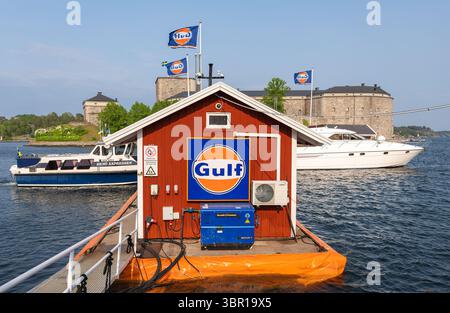 Vaxholm, Svezia - 4 giugno 2025: Stazione di rifornimento per imbarcazioni della Gulf Oil Corporation su un molo di Vaxholm con un edificio in legno rosso. Sullo sfondo, c'è Foto Stock