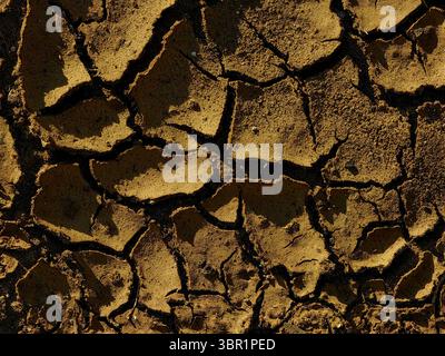 Terra spaccata a secco – prospettiva ravvicinata della superficie sabbiosa Foto Stock