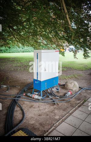 molti cavi di alimentazione portano a una scatola di alimentazione Foto Stock