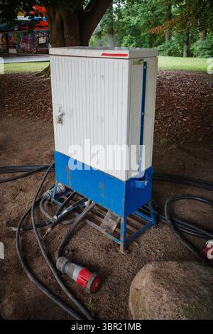 molti cavi di alimentazione portano a una scatola di alimentazione Foto Stock