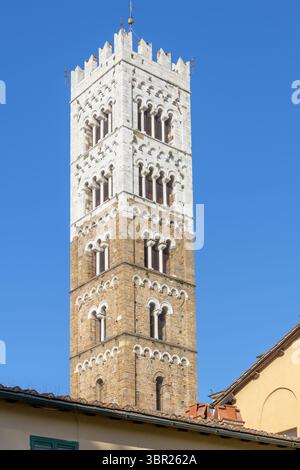 Campanile romanico della Cattedrale di San Martino a Lucca, Italia, con livelli alternati di pietra bianca e marrone, triplice lance e merlature. Foto Stock
