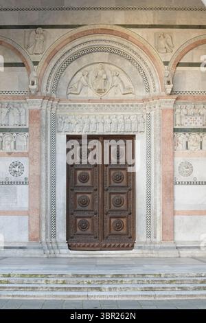 Portale principale della Cattedrale di San Martino a Lucca, Italia, con rilievi romanici, decorazioni in marmo policromo e porte in legno. Foto Stock