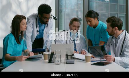 Gruppo di lavoro di squadra team multietnico diversi medici collaborazione persone mediche brainstorming utilizzando laptop discutere medicina malattia parlare paziente Foto Stock