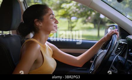 Felice calmo donna afroamericana seduta nuova auto di lusso realizzare sogno gioioso sorriso autista proprietario acquirente acquisto auto donna auto Foto Stock
