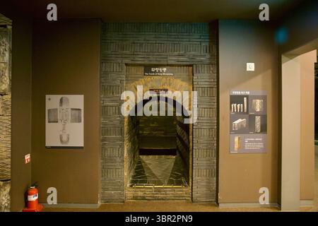 Gongju, Corea del Sud - 13 giugno 2025: Un arco in mattoni etichettato "la Tomba del Re Muryeong" conduce alla ricostruzione museale del buri del Re Baekje Foto Stock