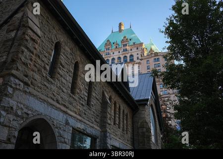 Vista laterale della Christ Church Cathedral con lo storico Fairmont Hotel Vancouver di fronte a West Georgia Street, Vancouver, British Columbia. Foto Stock