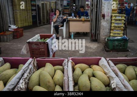 Bangkok, Thailandia. 11 luglio 2025. Scatole di mango impilate al mercato. Ogni mattina a Bangkok, i monaci buddisti camminano per le strade per ricevere elemosine, offerte di cibo e fiori, dalla comunità laica. Nelle vicinanze, al mercato dei fiori di Yodpiman, i fiori vengono preparati e venduti per l'uso in questi rituali quotidiani radicati nella tradizione buddista Theravada. Credito: SOPA Images Limited/Alamy Live News Foto Stock