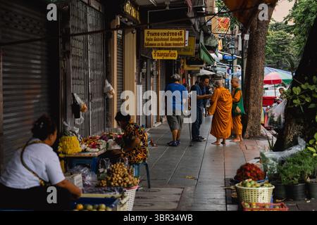 Bangkok, Thailandia. 11 luglio 2025. Una vista dei monaci buddisti che ricevono le elemosine mattutine dalla comunità laica, parte di un rituale quotidiano nello spazio urbano pubblico. Ogni mattina a Bangkok, i monaci buddisti camminano per le strade per ricevere elemosine, offerte di cibo e fiori, dalla comunità laica. Nelle vicinanze, al mercato dei fiori di Yodpiman, i fiori vengono preparati e venduti per l'uso in questi rituali quotidiani radicati nella tradizione buddista Theravada. (Foto di Ploy Phutpheng/SOPA Images/Sipa USA) credito: SIPA USA/Alamy Live News Foto Stock