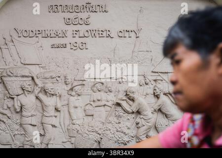 Bangkok, Thailandia. 11 luglio 2025. Segno inciso della città dei fiori di Yodpiman. Ogni mattina a Bangkok, i monaci buddisti camminano per le strade per ricevere elemosine, offerte di cibo e fiori, dalla comunità laica. Nelle vicinanze, al mercato dei fiori di Yodpiman, i fiori vengono preparati e venduti per l'uso in questi rituali quotidiani radicati nella tradizione buddista Theravada. (Foto di Ploy Phutpheng/SOPA Images/Sipa USA) credito: SIPA USA/Alamy Live News Foto Stock
