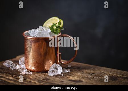Cocktail ghiacciato di mugle di Mosca con birra allo zenzero e vodka su sfondo scuro Foto Stock