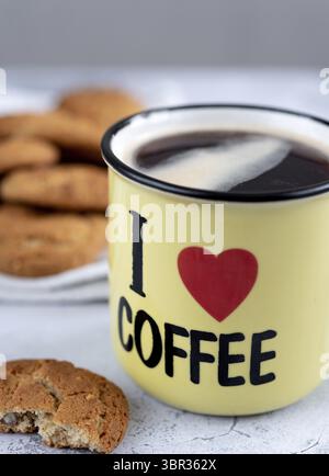 Tazza gialla con caffè aromatico con l'iscrizione che amo biscotti al caffè e alla farinata d'avena Foto Stock