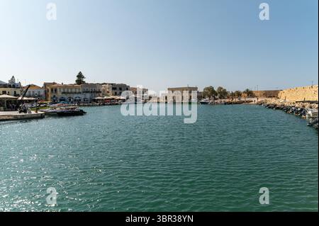 Rethymno, Creta, Grecia - 22 giugno 2025: I turisti passeggiano lungo il lungomare di Rethymno, godendosi il vivace paesaggio e le barche. Foto Stock