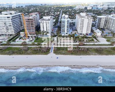 La vista aerea della costa rivela il forte contrasto tra l'oceano turchese e la spiaggia liscia e sabbiosa, gli edifici per riunioni, Surfside, Florida, Stati Uniti Foto Stock