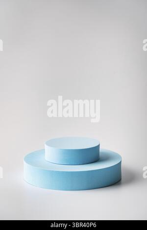 Stand pubblicitario per prodotti cosmetici. Podio blu da esposizione con forme geometriche su sfondo bianco. Piedistallo vuoto per visualizzare la confezione del prodotto Foto Stock