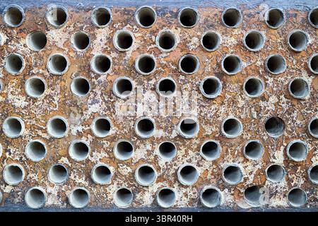 Piastra tubiera di scambiatore di calore o di boiler struttura di primo piano macrofirico fondo industriale con depositi minerali duri insolubili sali scala di saldatura cordoni di saldatura Foto Stock