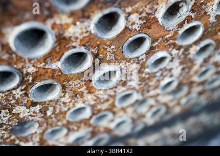 Piastra tubolare dello scambiatore di calore o della caldaia primo piano texture focale selettiva sfondo industriale con depositi di minerali duri insolubili sali scala WE Foto Stock