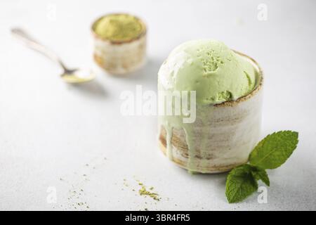 Tazza di gelato al tè verde su fondo bianco Foto Stock