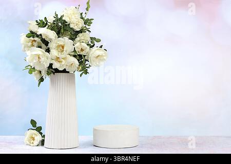 Bellissimi rami primaverili in fiore di rose fianchi e rose in un vaso su uno sfondo soleggiato, striscione. Composizione floreale astratta con podio vuoto per p Foto Stock