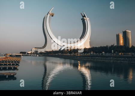 Doha, città di Lusail, Qatar - 1° febbraio 2025: Torre a mezzaluna dall'isola di al Maha in Qatar, con un cielo dai colori vivaci prima del tramonto Foto Stock