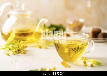 Tazza di tè alle erbe con fiori di tiglio su sfondo bianco Foto Stock