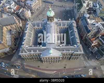 Veduta aerea del Palazzo reale di pietra pallida che si erge maestosamente tra le vivaci strade della città, con la guglia di Nieuwe Kerk che si innalza in lontananza, Amsterdam, Olanda settentrionale, Paesi Bassi. Foto Stock