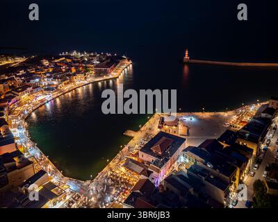 Vista aerea del porto veneziano con le sue luci colorate che si riflettono sull'acqua, il faro che si erge in lontananza, la Canea, la Grecia. Foto Stock