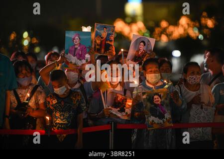 12 agosto 2020, Bangkok, Tailandia: I benestanti thailandesi tengono le foto della regina Sirikit mentre assistono alla celebrazione del suo 88° compleanno a Sanam Luang. (Immagine di credito: Immagini © Amphol Thongmueangluang/SOPA tramite cavo ZUMA) Foto Stock