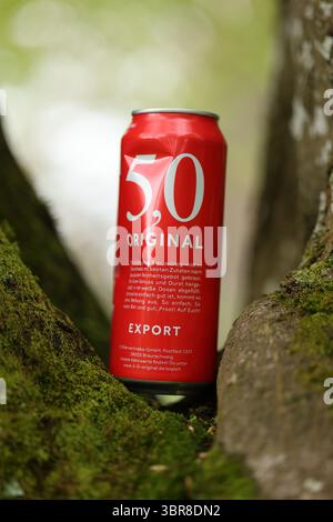 Una lattina rossa di 50 birre originali si trova su un ramo d'albero Foto Stock