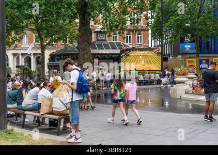 Persone che guardano il tennis da Wimbledon su un grande schermo a Leicester Square, nel centro di Londra. Foto Stock
