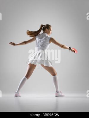 Atleta femminile che gioca a ping pong con intensità e stile Foto Stock