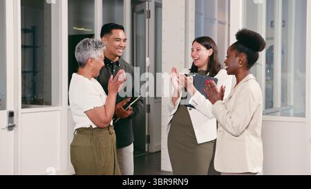 Colleghi che condividono un momento di gioia mentre celebrano il successo in un ambiente d'ufficio moderno Foto Stock