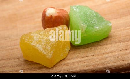 Pezzi di dolciumi dolci dai colori vivaci si trovano su una tavola di legno. Foto Stock