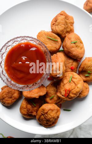 Vista dall'alto di Akara su un piatto bianco, vista dall'alto della torta di fagioli fritti di akara nigeriana su un piatto Foto Stock