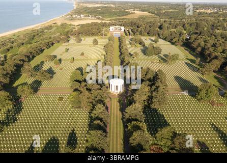 Vista aerea di file di croci bianche che si estendono attraverso il verde paesaggio verso il mare, con monumenti bianchi in solenne ricordo, Colleville-sur-Mer, Normandia, Francia. Foto Stock