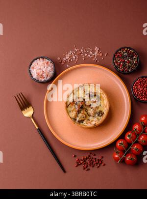 Torta o quiche, una crostata acida con pollo e funghi, spezie ed erbe aromatiche su sfondo di cemento scuro. Quiche rotonde con pollo Foto Stock