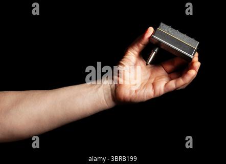 amplug in mano su sfondo nero Foto Stock