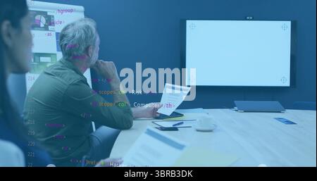 Rivedere i documenti di un uomo che indossa una camicia verde nella sala riunioni dell'ufficio, lavagna a fogli mobili, spazio per fotocopie Foto Stock