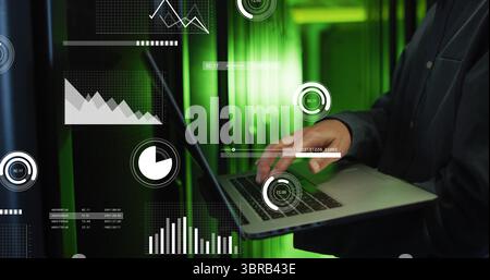 Ingegnere IT coreano maturo che tiene un laptop nella corsia del data center, con sovrapposizioni e spazio di copia Foto Stock