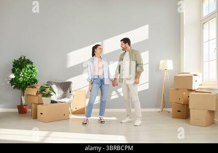 Coppia felice, famiglia giovane festeggiano il trasferimento in piedi in un nuovo appartamento moderno, marito, moglie Foto Stock