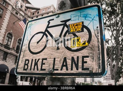 Segnaletica della pista ciclabile sporca con graffiti Foto Stock