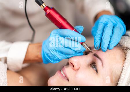 Tatuaggio semi-permanente delle sopracciglia. Si tratta di una procedura cosmetica che migliora l'aspetto delle sopracciglia. Foto Stock