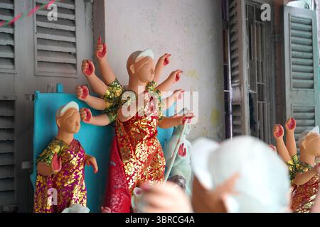 Durga Idol a metà finito attende i ritocchi finali al Kumartuli Workshop Foto Stock
