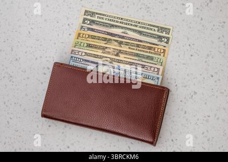 Portafoglio in pelle marrone con banconote in dollari USA da 1, 2, 5, 10, 20, 50 e 100 tagli Foto Stock