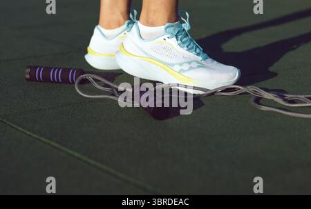 Donna sportiva in scarpe da ginnastica e corda da salto Foto Stock