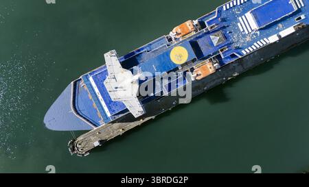 Vista aerea di un traghetto Interislander attraccato, il suo ponte blu che contrasta con lo scafo scuro e le acque verdi smeraldo circostanti, Picton e Marlboroug Foto Stock