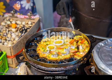 Venditrice di strada che prepara pancake di omelette di gamberi piccanti tailandesi, Bangkok, Thailandia Foto Stock