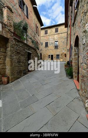 074 muratura in pietra e mattoni, case medievali su entrambi i lati di via dei Fabbri che raggiungono via Bedini. Monticchiello-Toscana-Italia. Foto Stock
