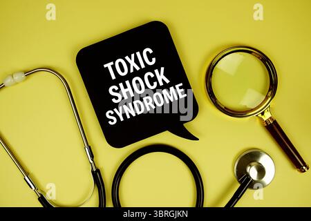 Messaggio di testo sulla sindrome da shock tossico su carta con lente d'ingrandimento stetoscopio su sfondo in legno Foto Stock