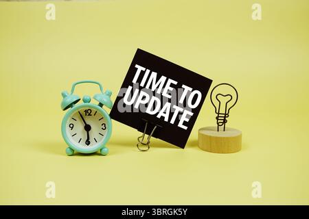 Messaggio di testo Time for Update su carta con allarme clcok su sfondo giallo Foto Stock